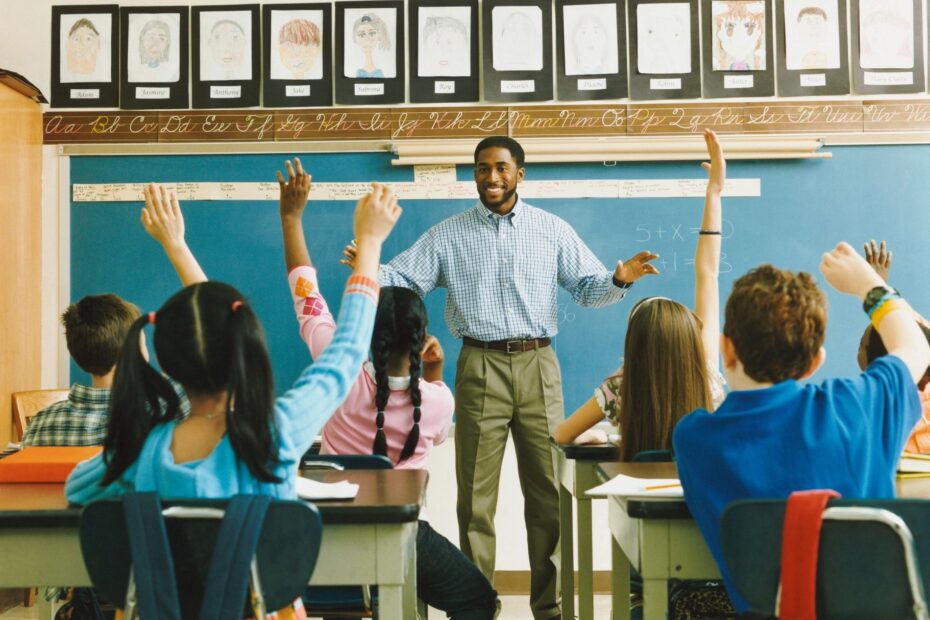 Teacher and students raising hands